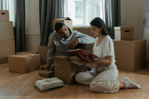 man and woman unpacking books in their new home