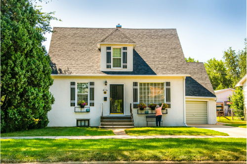 real estate white house with three windows in the front and wide front yard